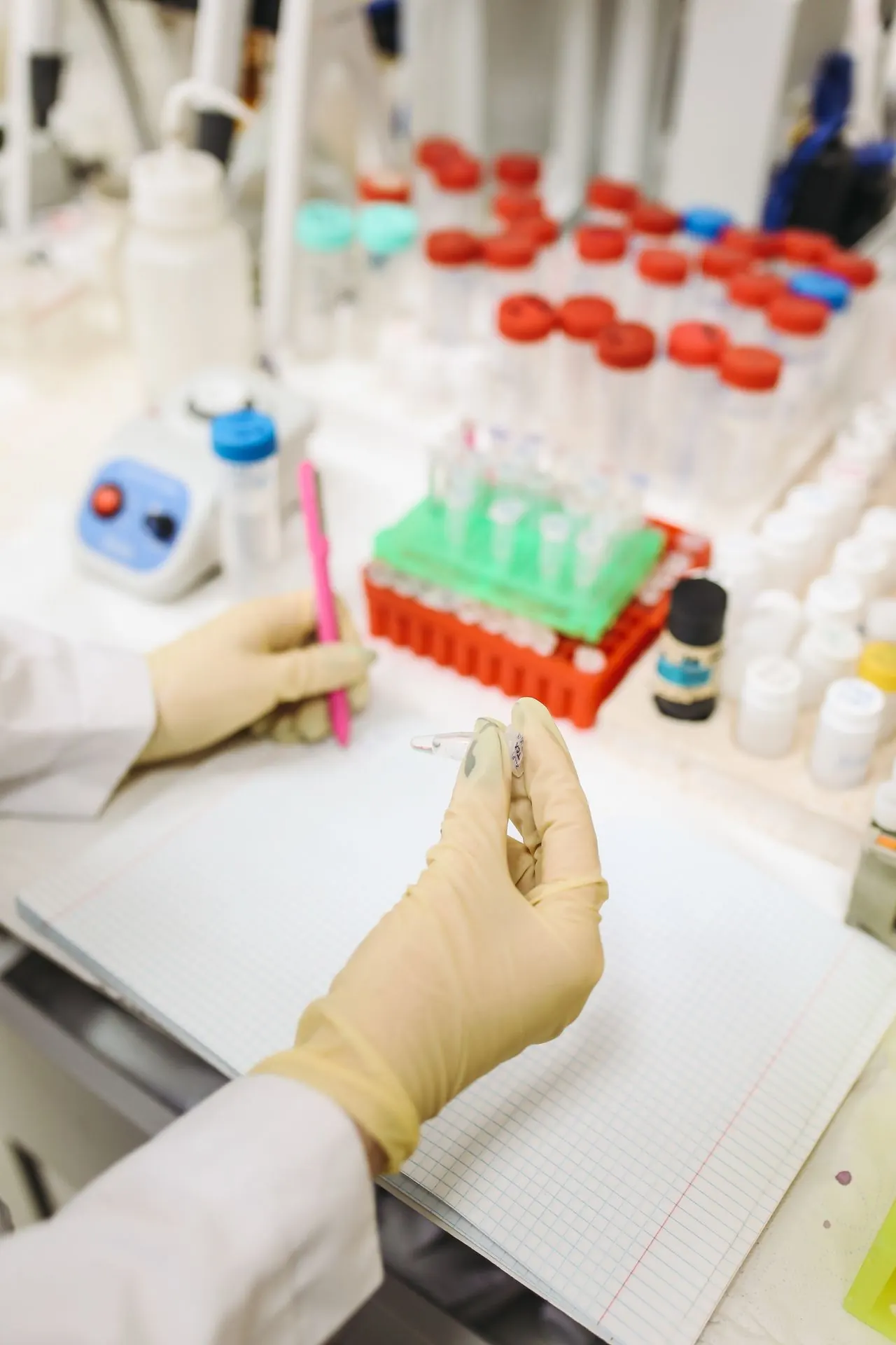 Une scientifique portant des gants examine des échantillons en laboratoire