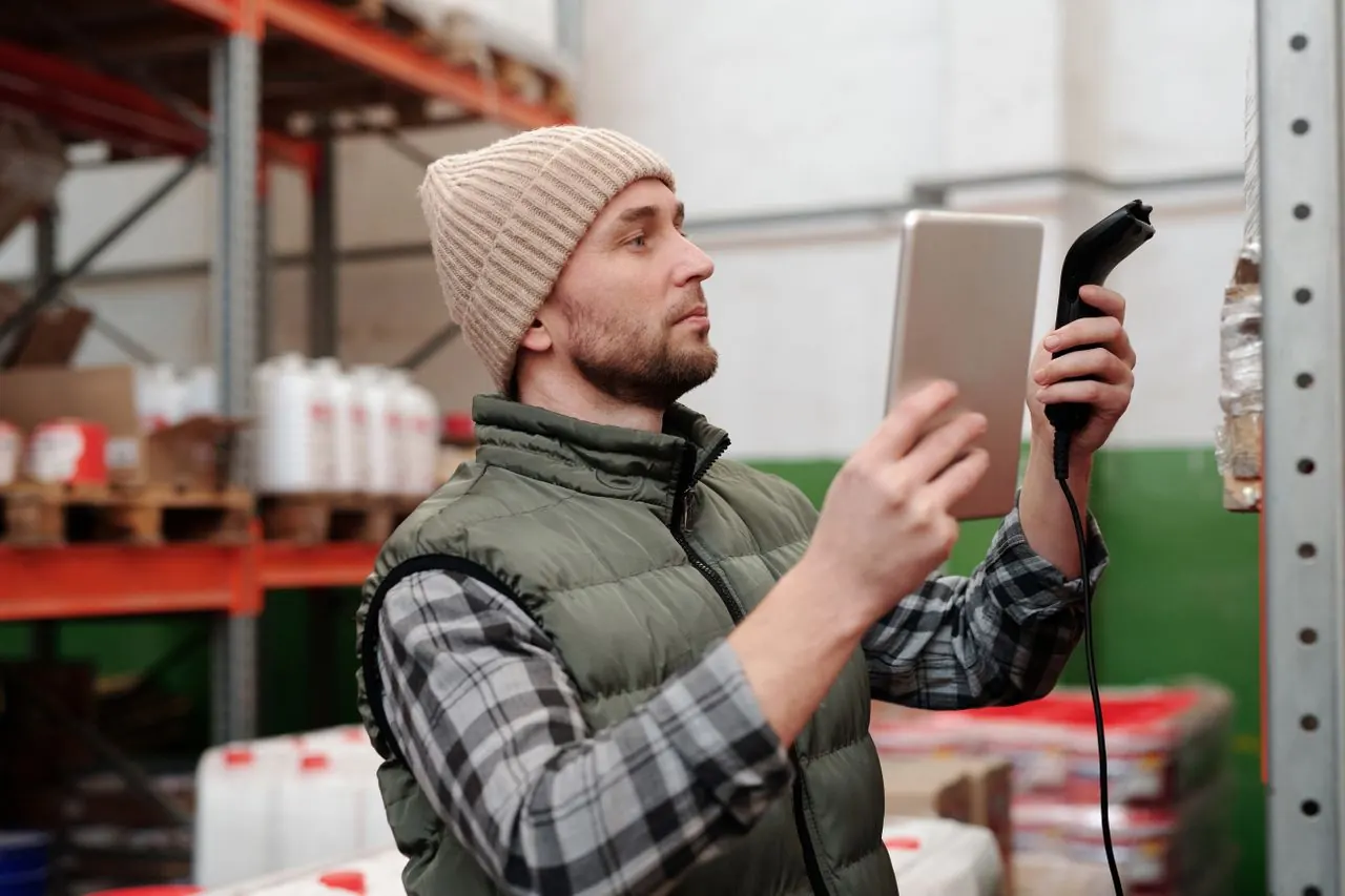 Un professionnel utilise un lecteur pour suivre des produits en entrepôt